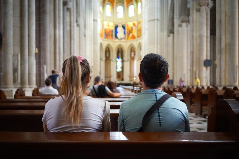 Paar zit samen in de kerkbank, gericht op het altaar