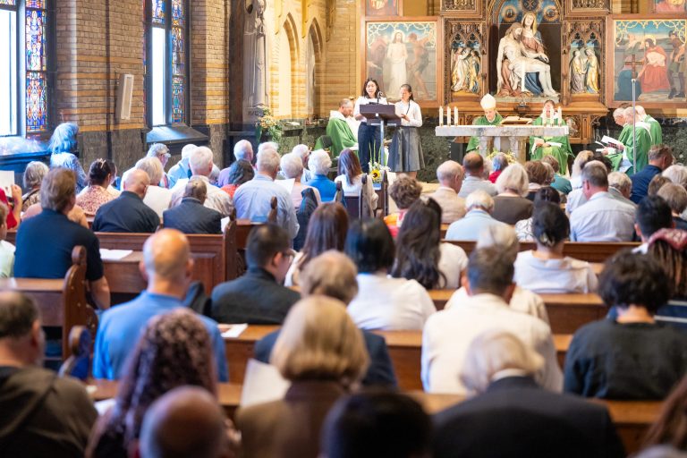 Eucharistieviering met bisschop, de gemeenschap van achteren gezien
