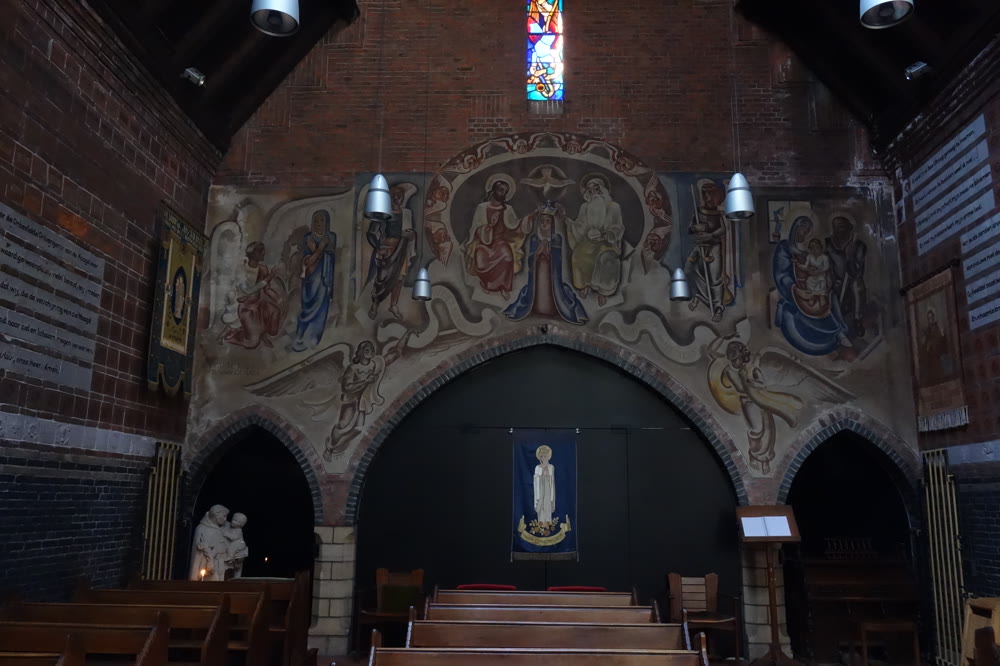 De beschilderde boog boven de Lourdesgrot in de kapel